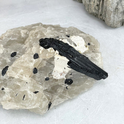 up close shot of Black Tourmaline on Matrix with decorations in the background