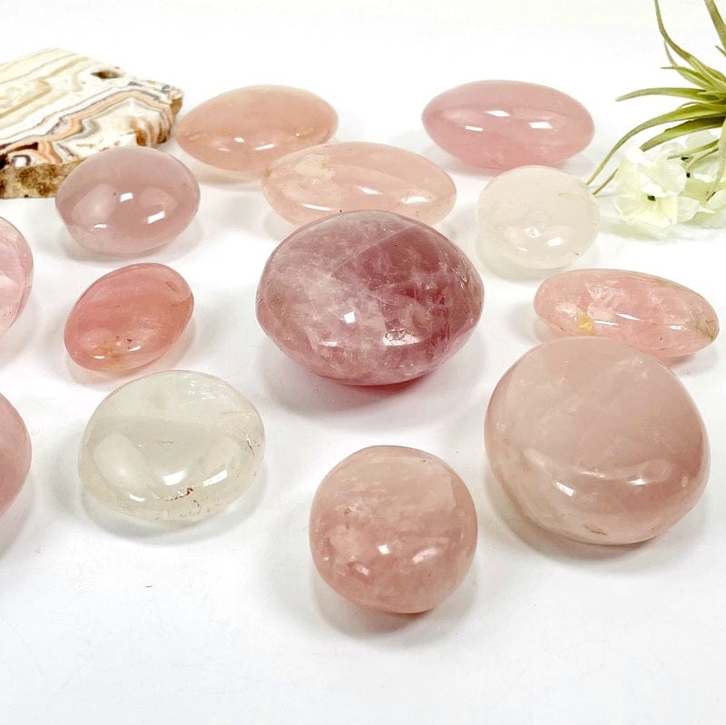 side shot of the rose quartz palm stones showing the different thicknesses 