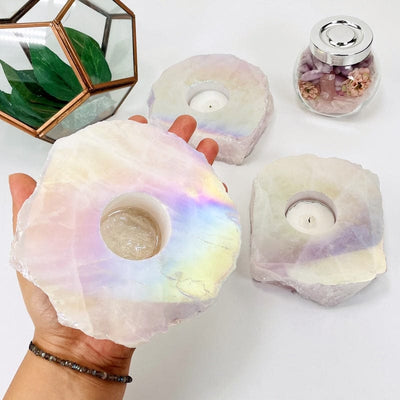 angel aura coated rose quartz candle holder in hand for size reference 