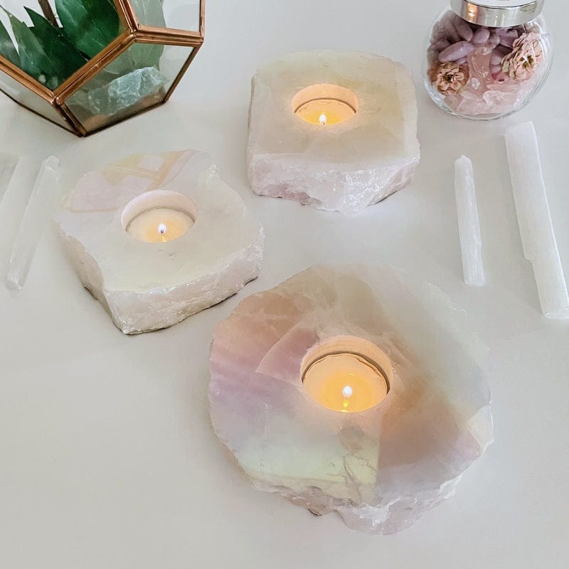 multiple angel aura coated rose quartz candle holders displaying the different possible sizes 