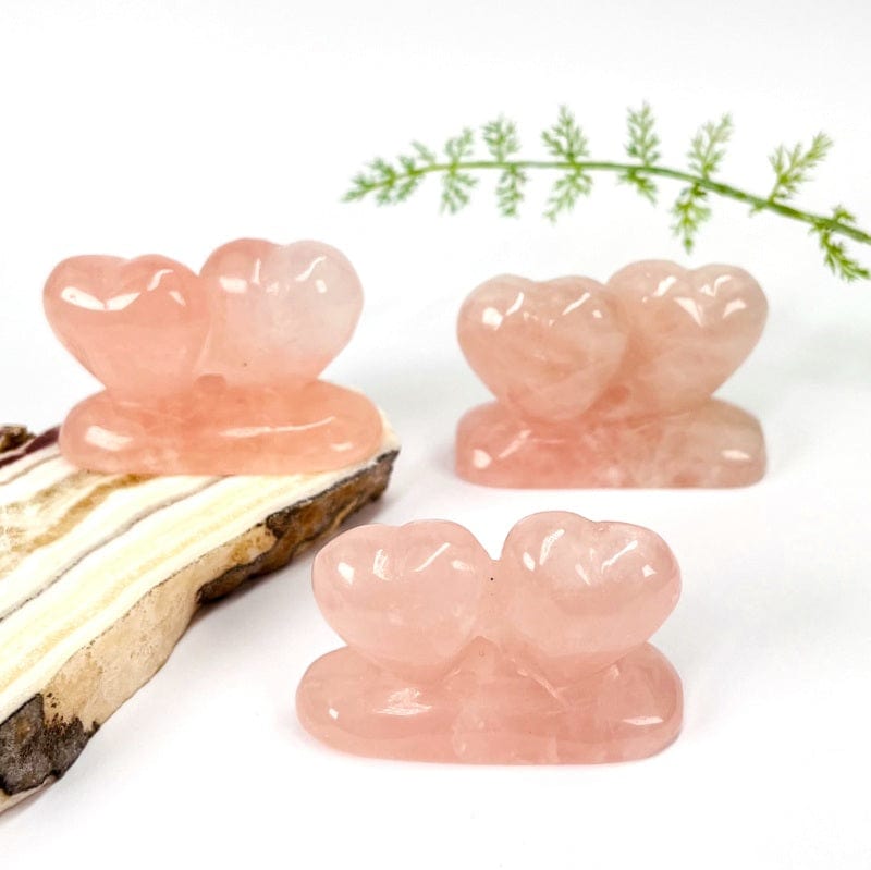 multiple double hearts carved rose quartz stones displayed as home decor