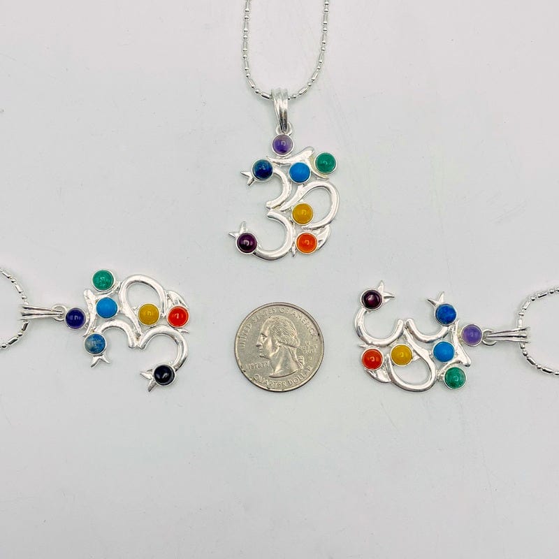 chakra om pendants next to a quarter for size reference