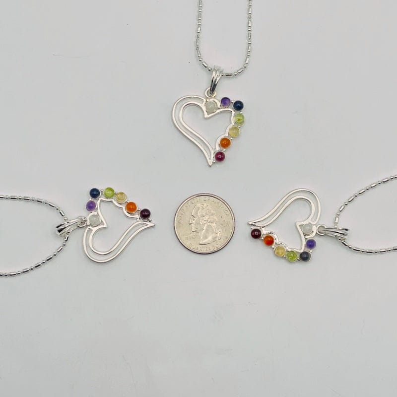 chakra heart pendants next to a quarter for size reference