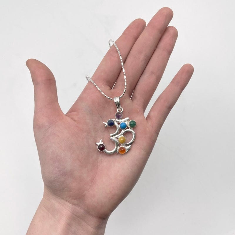 chakra om pendant necklace in hand for size reference