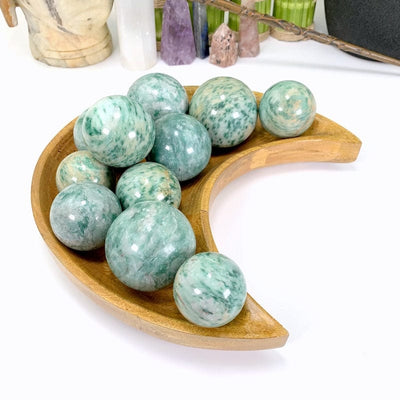 11 fuchsite spheres in a wood tray with a white background
