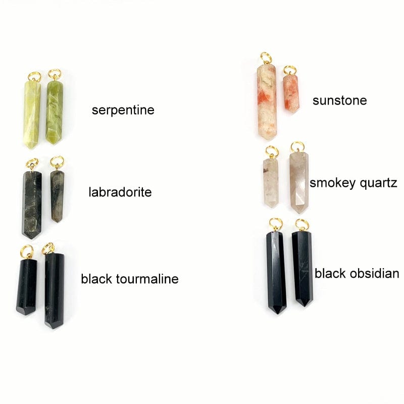 close up of serpentine, labradorite, black tourmaline, sunstone, smokey quartz and black obsidian gemstone pencil point pendants with circle gold toned bails 