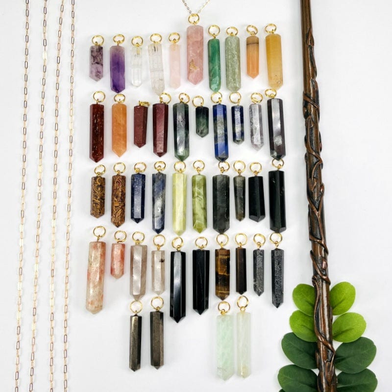 multiple pencil point gemstone pendants with gold circle bails displayed next to each other to show the differences in the sizes and the stone variations 