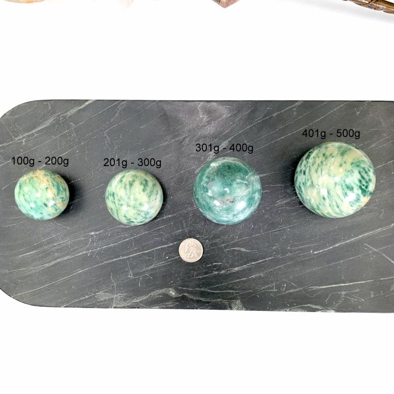 all 4 variations labeled on a black marble tray next to a quarter