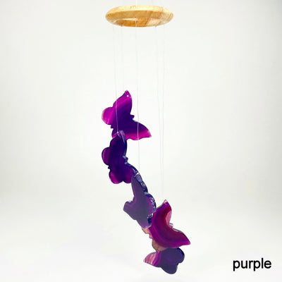 one purple agate butterfly wind chime hanging in front of white background