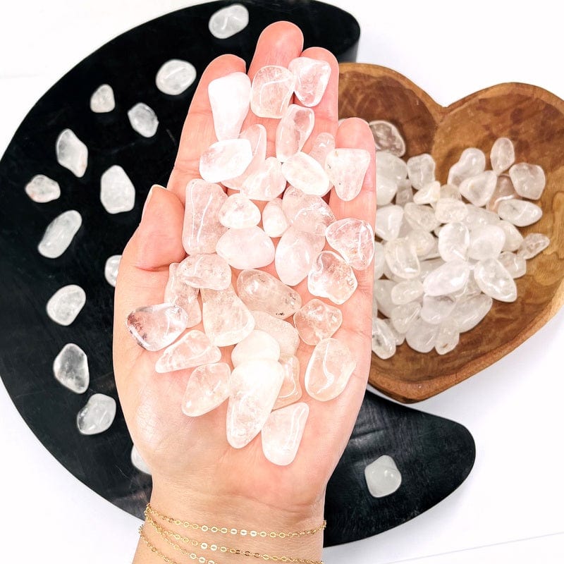tumbled crystal quartz gemstones in hand for size reference 