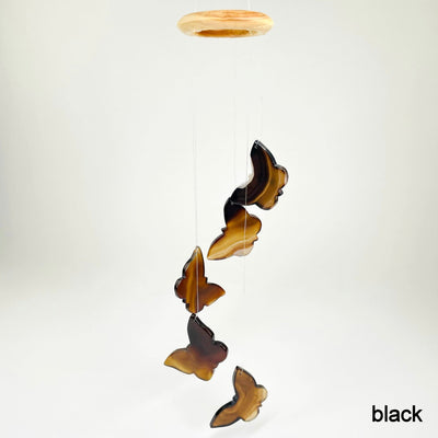 one black agate butterfly wind chime hanging in front of white background