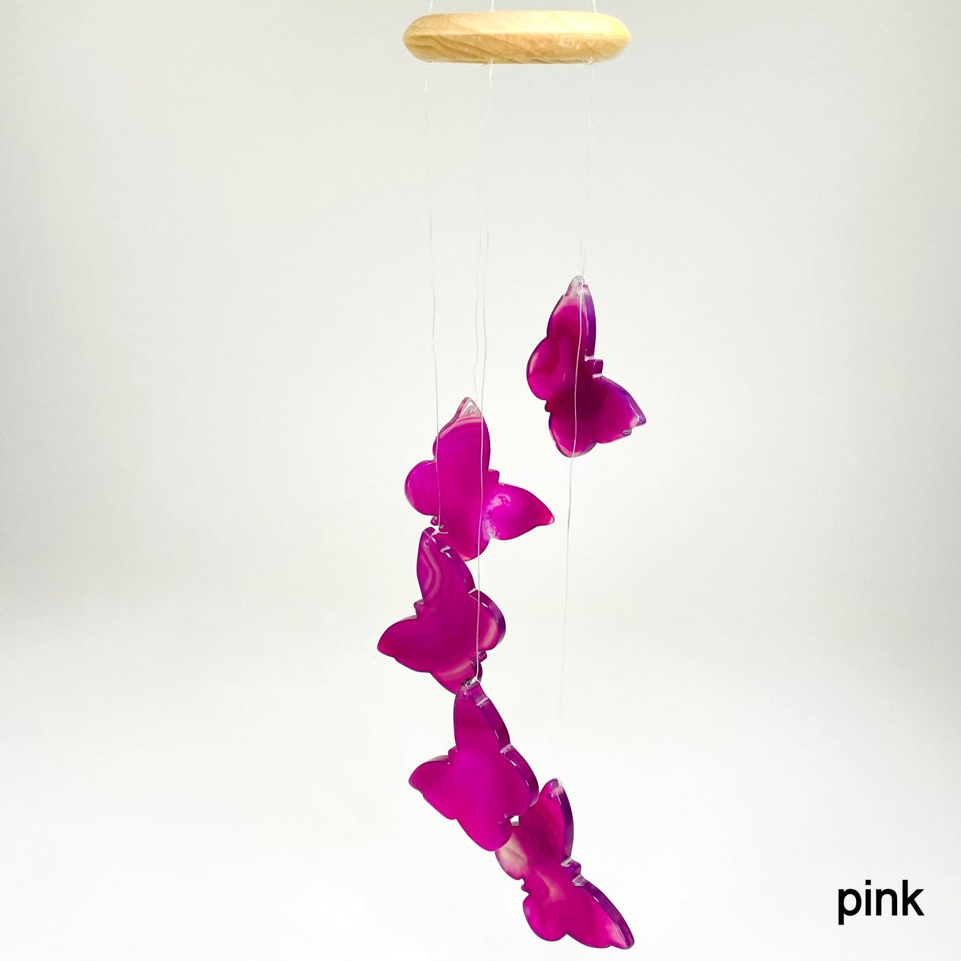 one pink agate butterfly wind chime hanging in front of white background