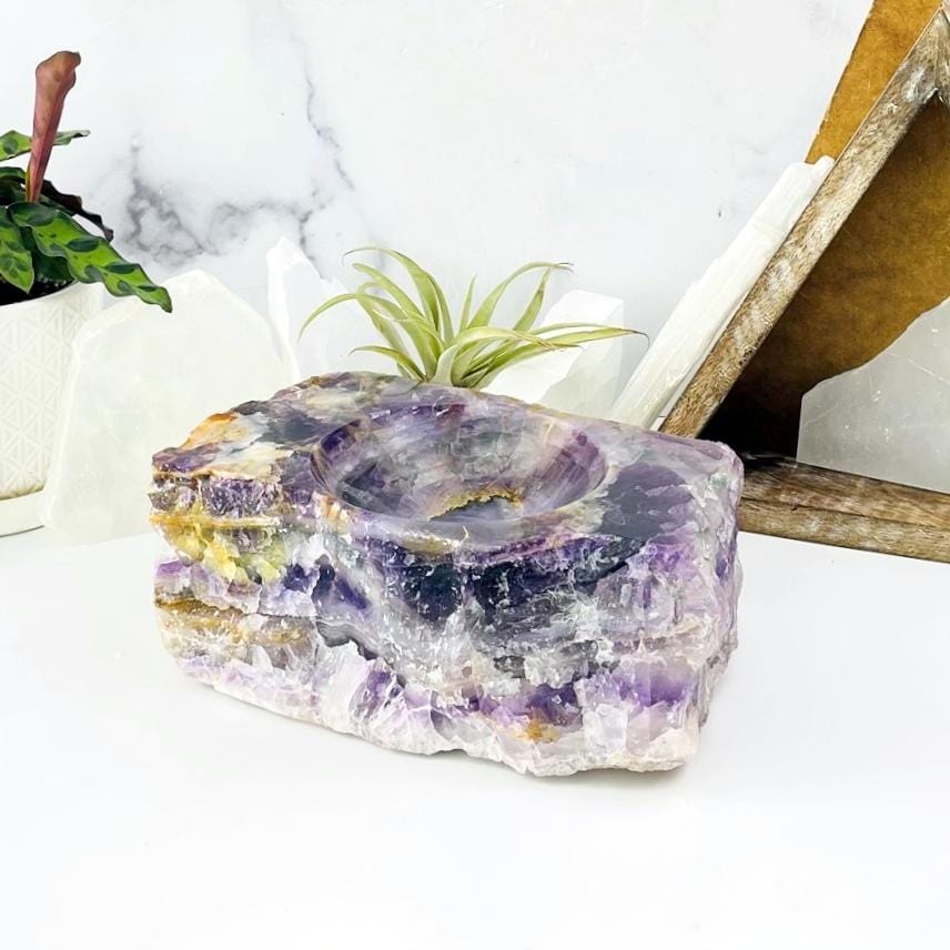 Side view of Rainbow Flourite Display Bowl on white table with various decorations in the background