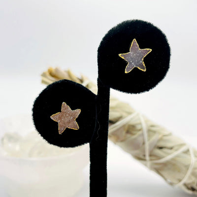 close up of one pair of gold natural druzy star stud earrings on display