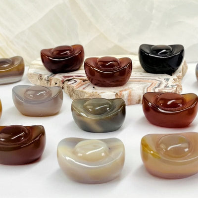 yuanbao shaped carved carnelian stones displayed to show the differences in the color patterns