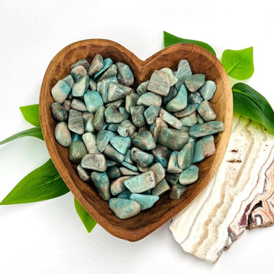 one pound of amazonite tumbled stones in a wooden heart bowl set up as home decor 