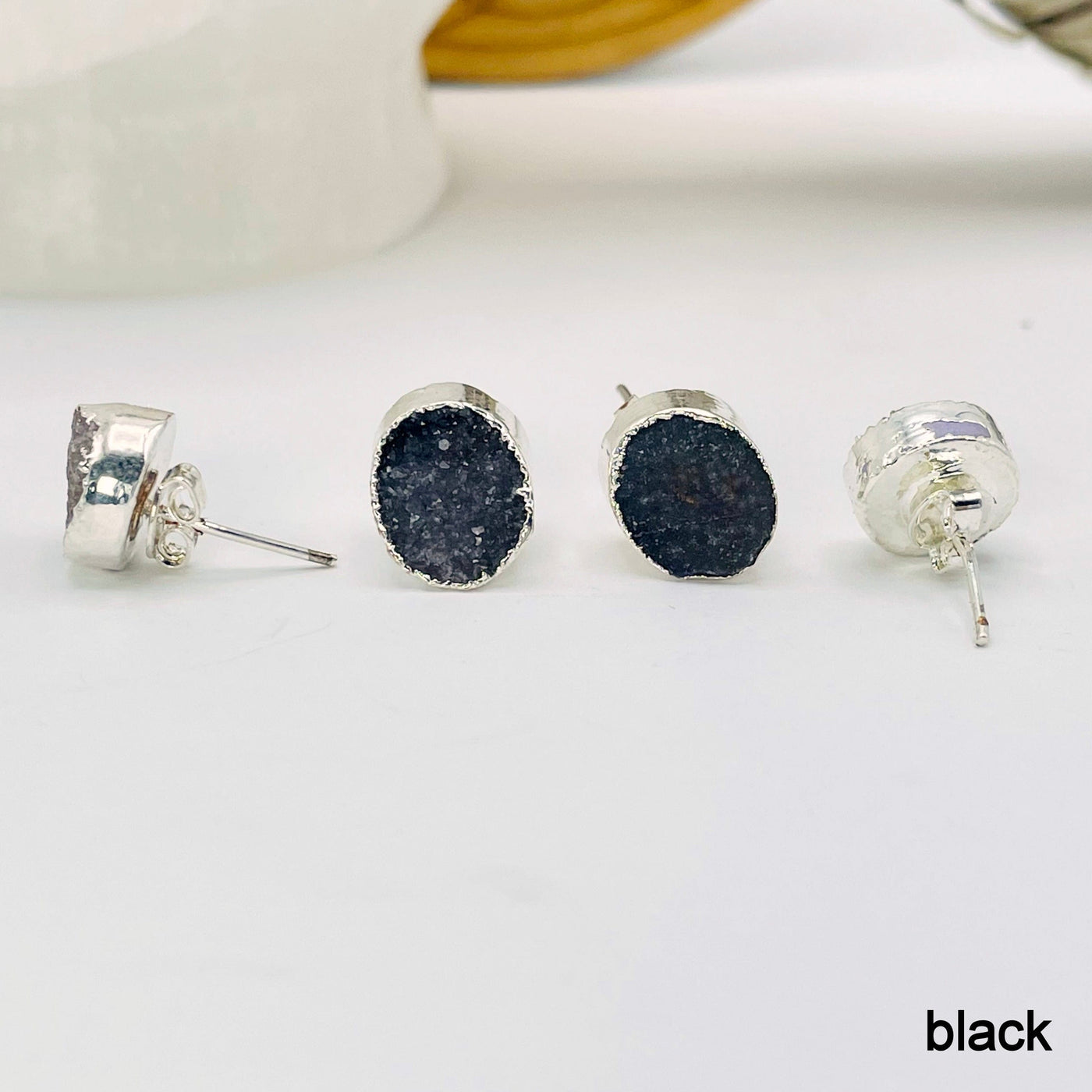 close up of four black round druzy stud earrings for side, front, and back view