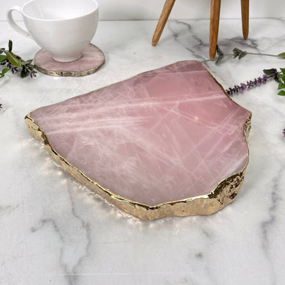 angled view of rose quartz platter with gold electroplated edge for thickness