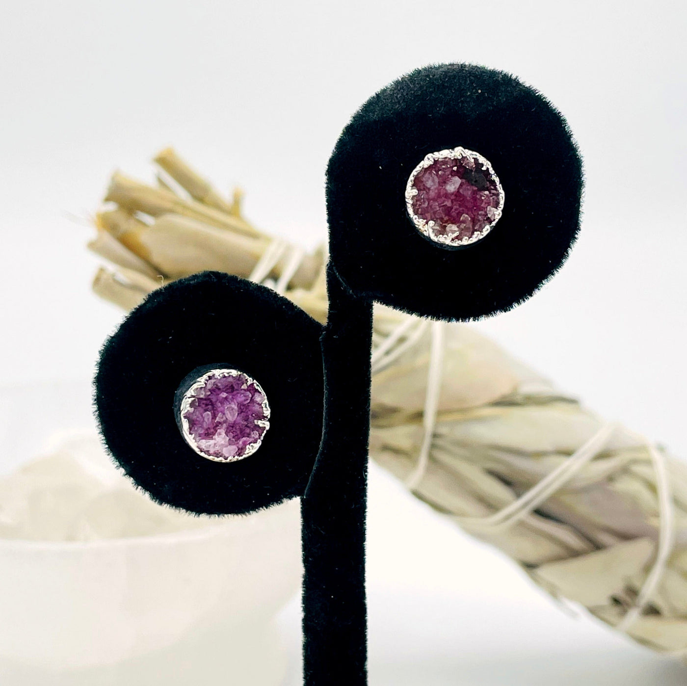 close up of one pair of pink round druzy stud earrings on display