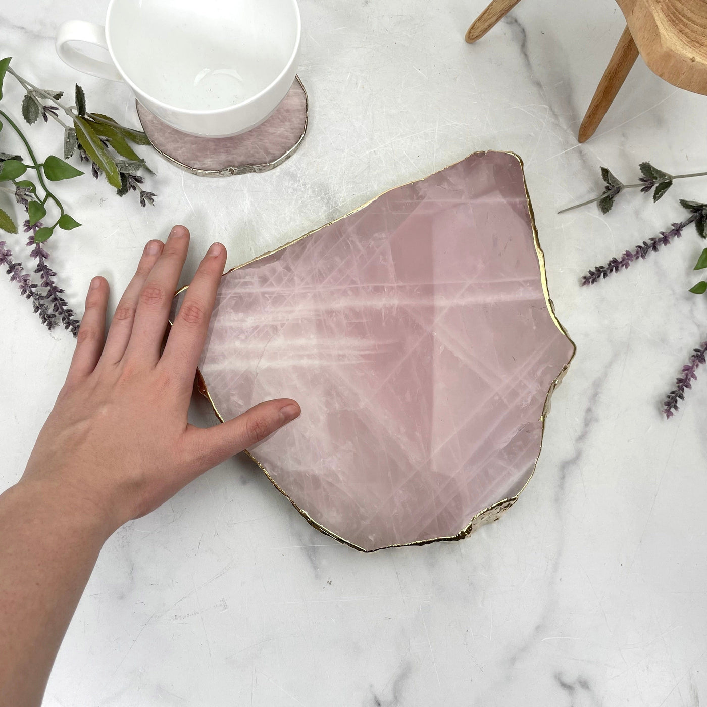 rose quartz platter with gold electroplated edge with hand for size reference