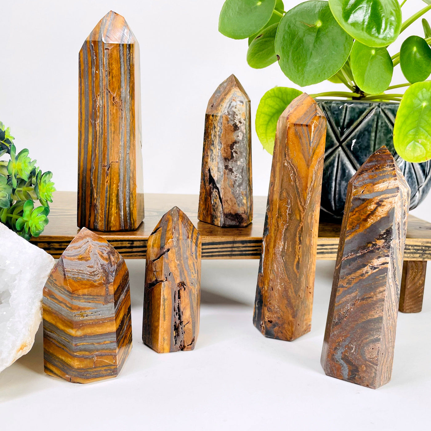 many different tiger eye polished point weights on display