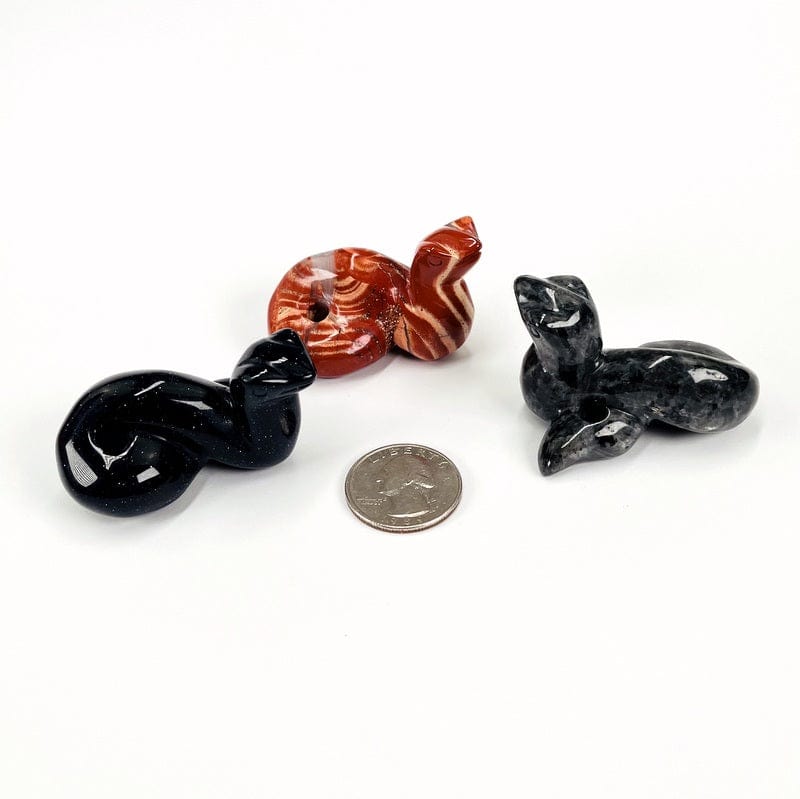 gemstone snakes next to a quarter for size reference 