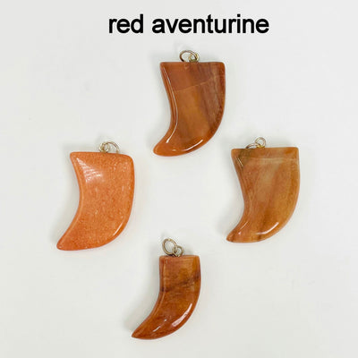close up of four tumbled red aventurine horn pendants on white background for details and possible variations