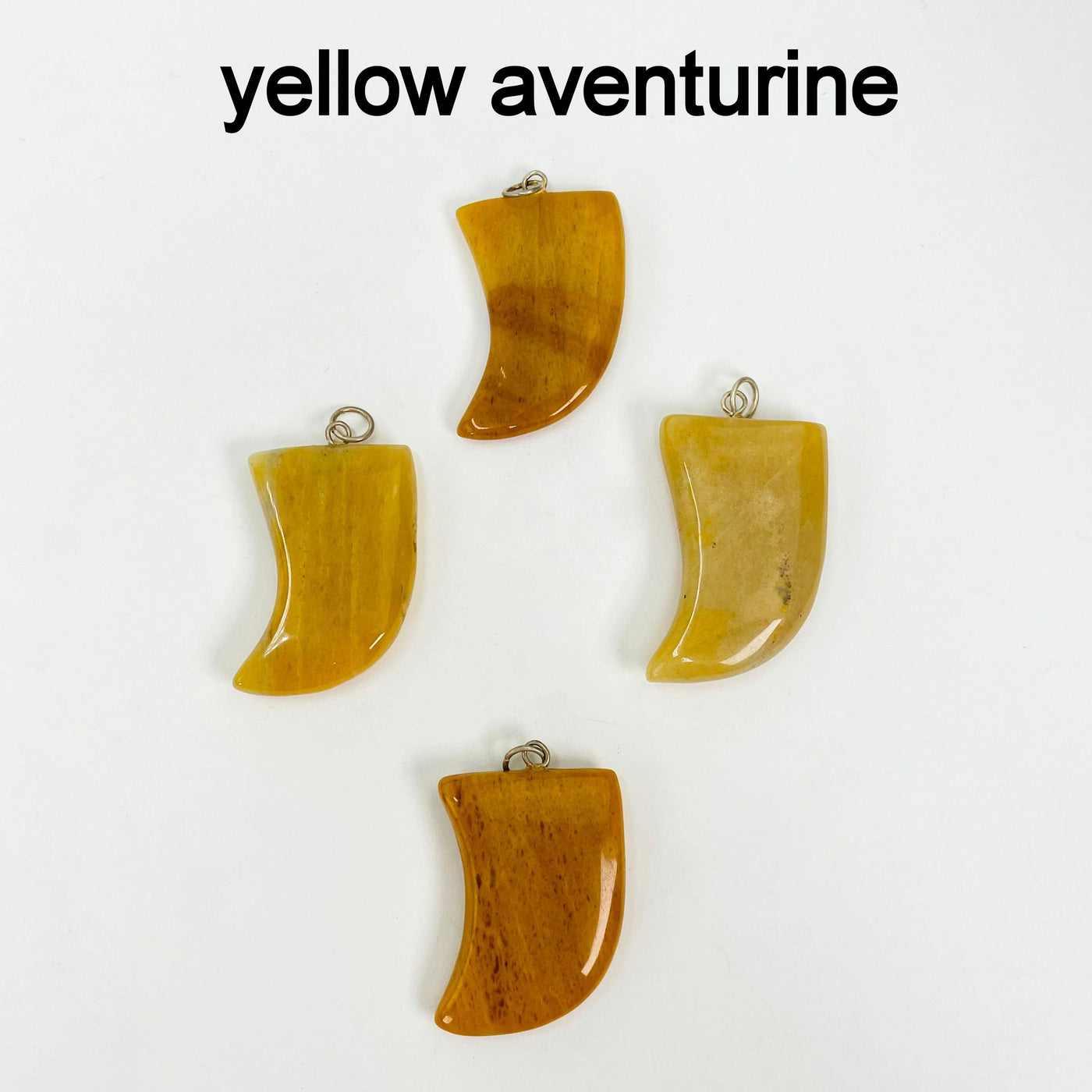 close up of four tumbled yellow aventurine horn pendants on white background for details and possible variations