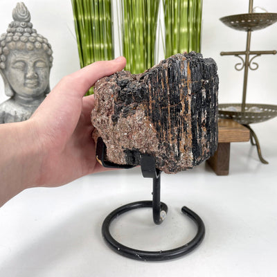 black tourmaline on stand in hand for size reference