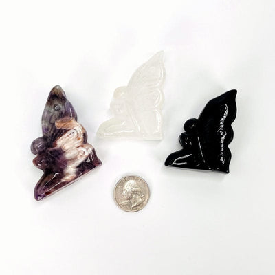 butterfly goddess carved stones next to a quarter for size reference 