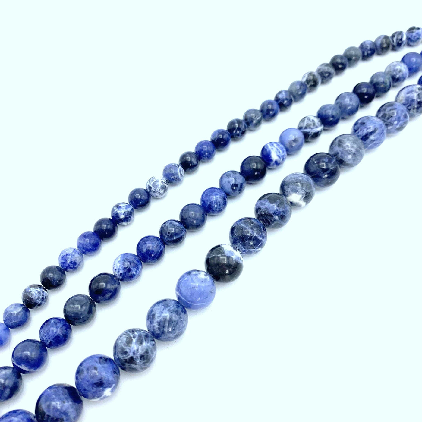 all 3 strands of sodalite beads from smallest to biggest (left to right) on a white background