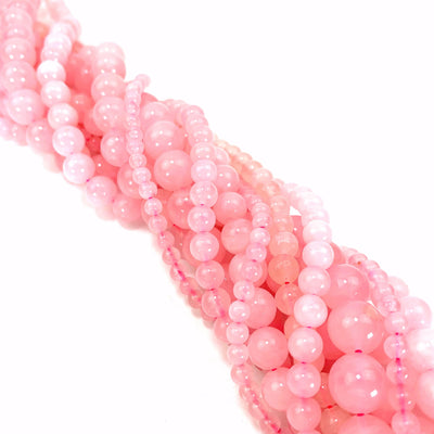 photo of rose quartz bead strands in a bundle on white background