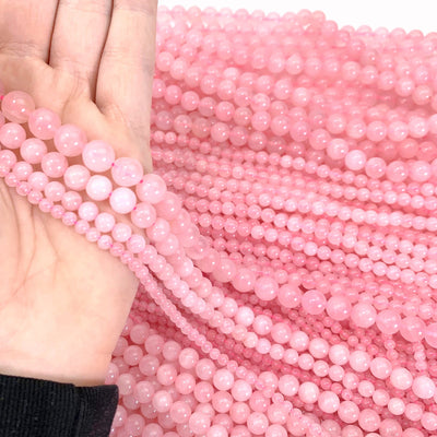 rose quartz beads in the sizes for sale in a hand