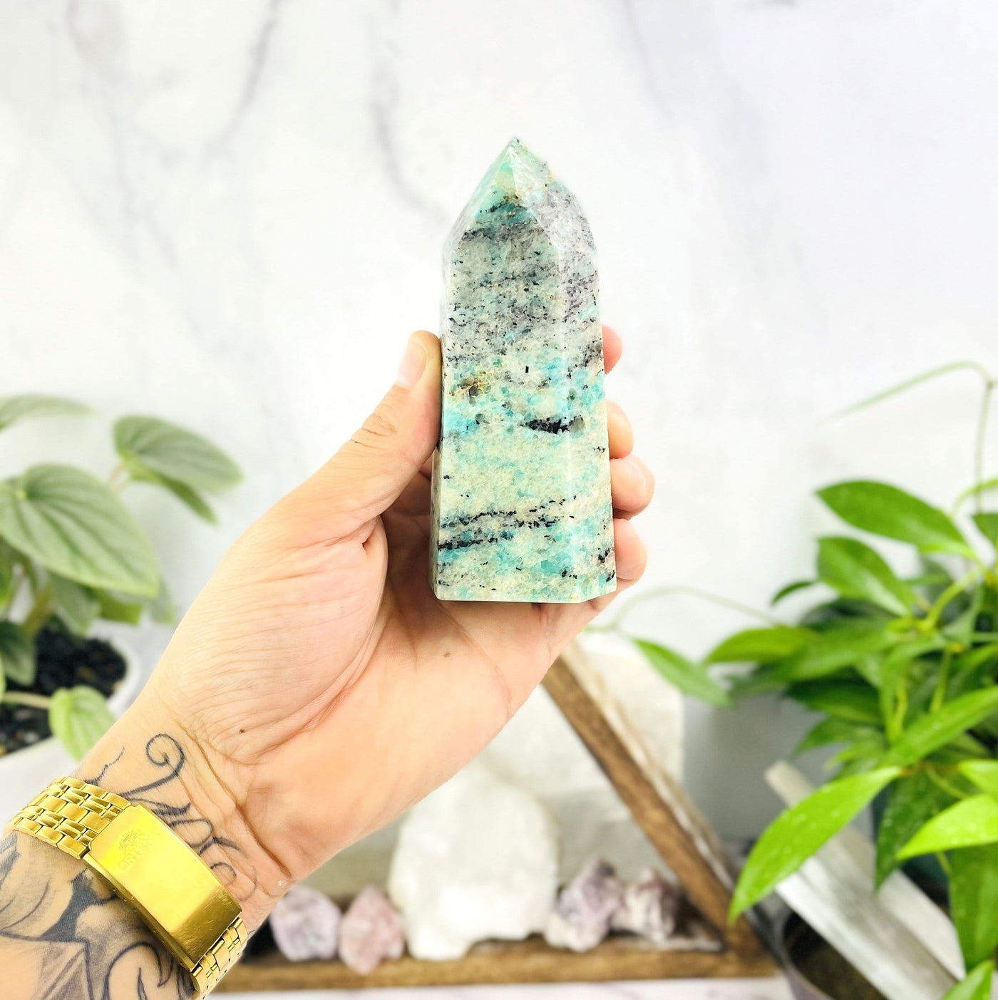 amazonite point being held for size reference.
