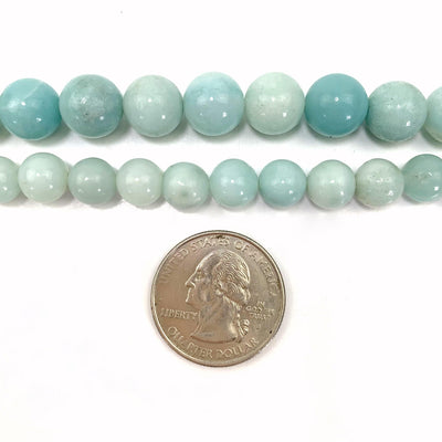 both sizing variations of amazonite on a white background with a quarter next to them