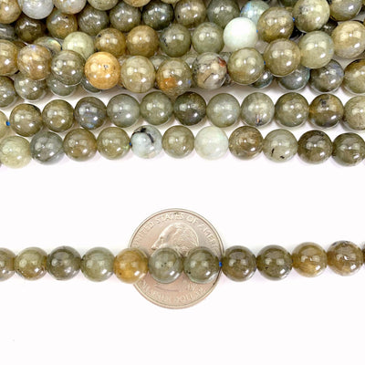 Dark Labradorite Beads On a White Background Over a Quarter.