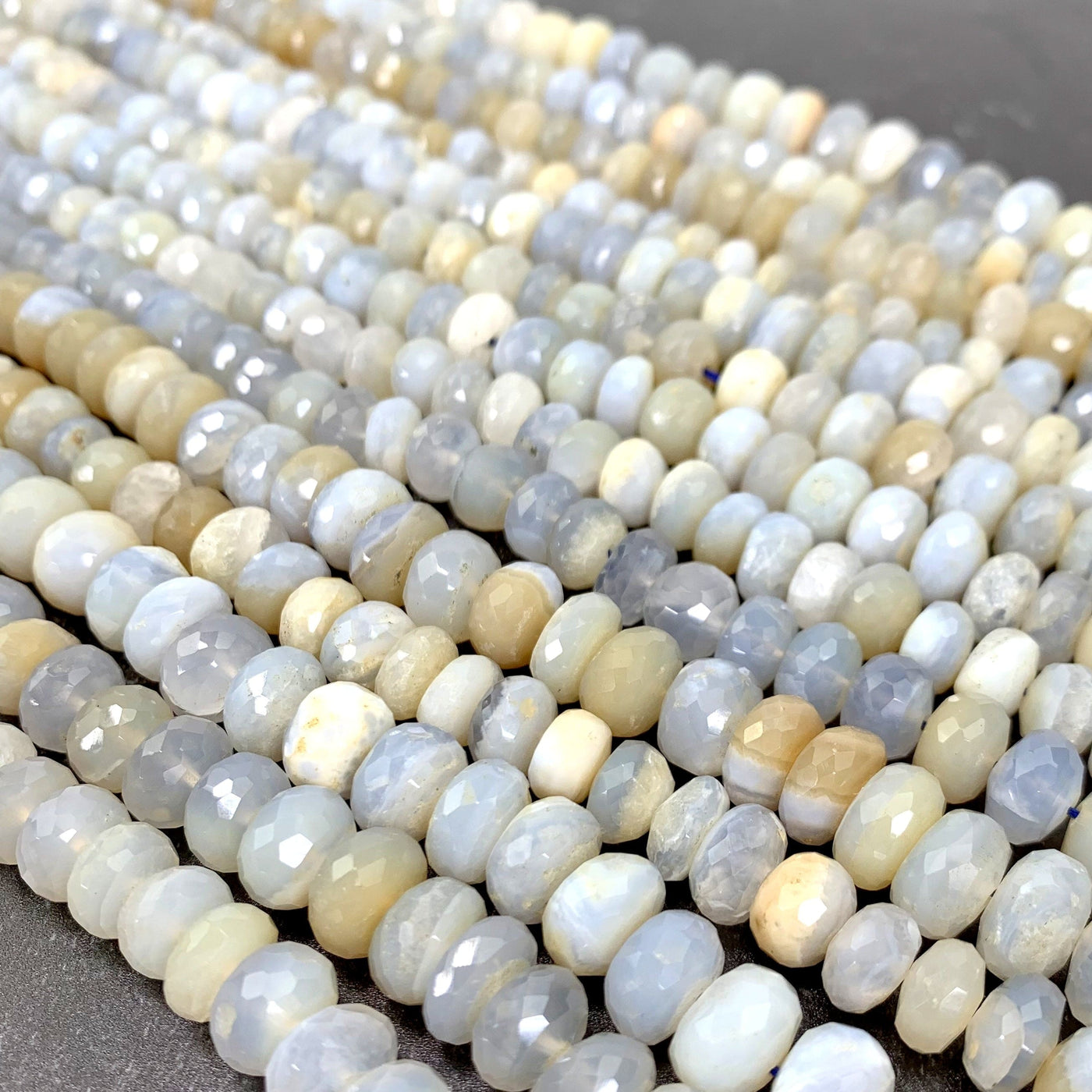 faceted round chalcedony beads laid out on a black background