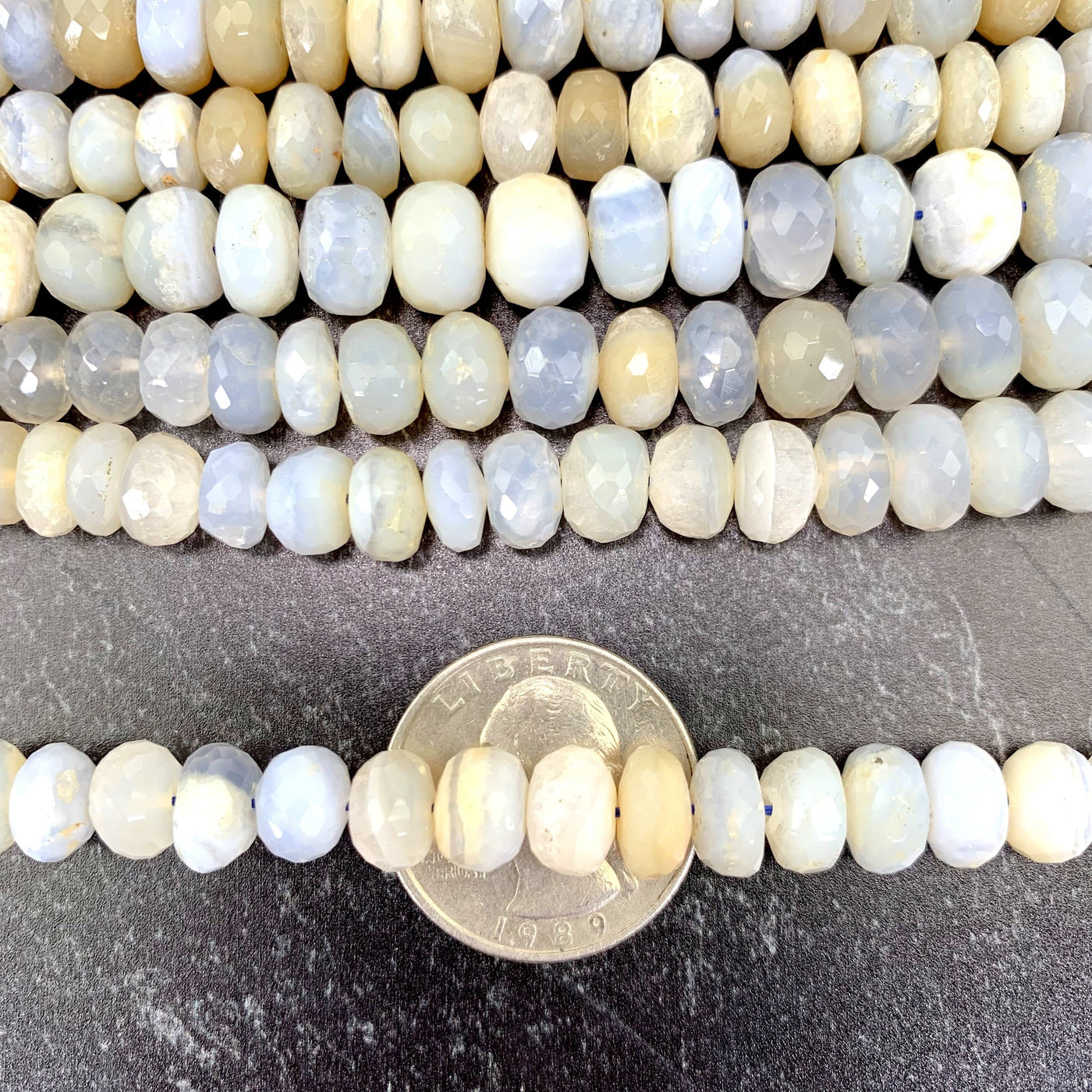 faceted round chalcedony beads on quarter with black background