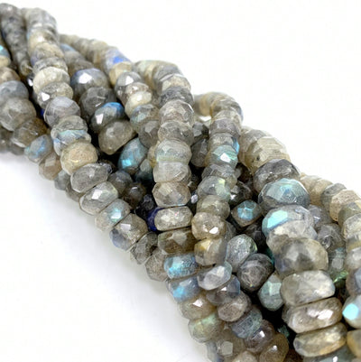 FACETED ROUND LABRADORITE BEADS twisted together on a white surface