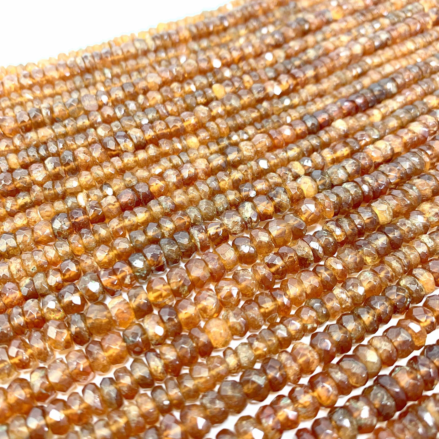 hessonite beads laid out on a white background