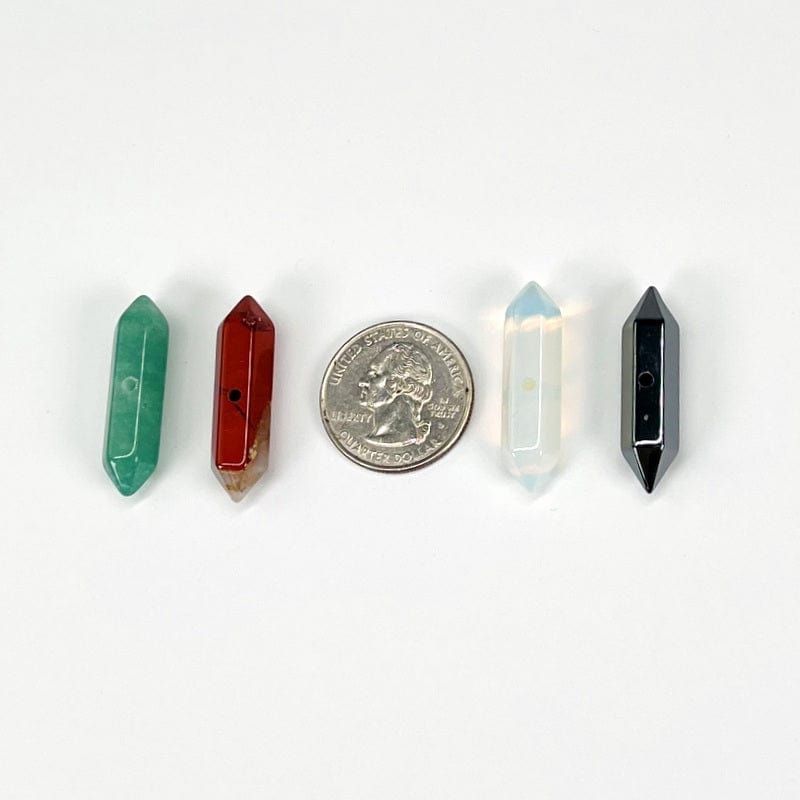 double terminated pencil point beads next to a quarter for size reference 
