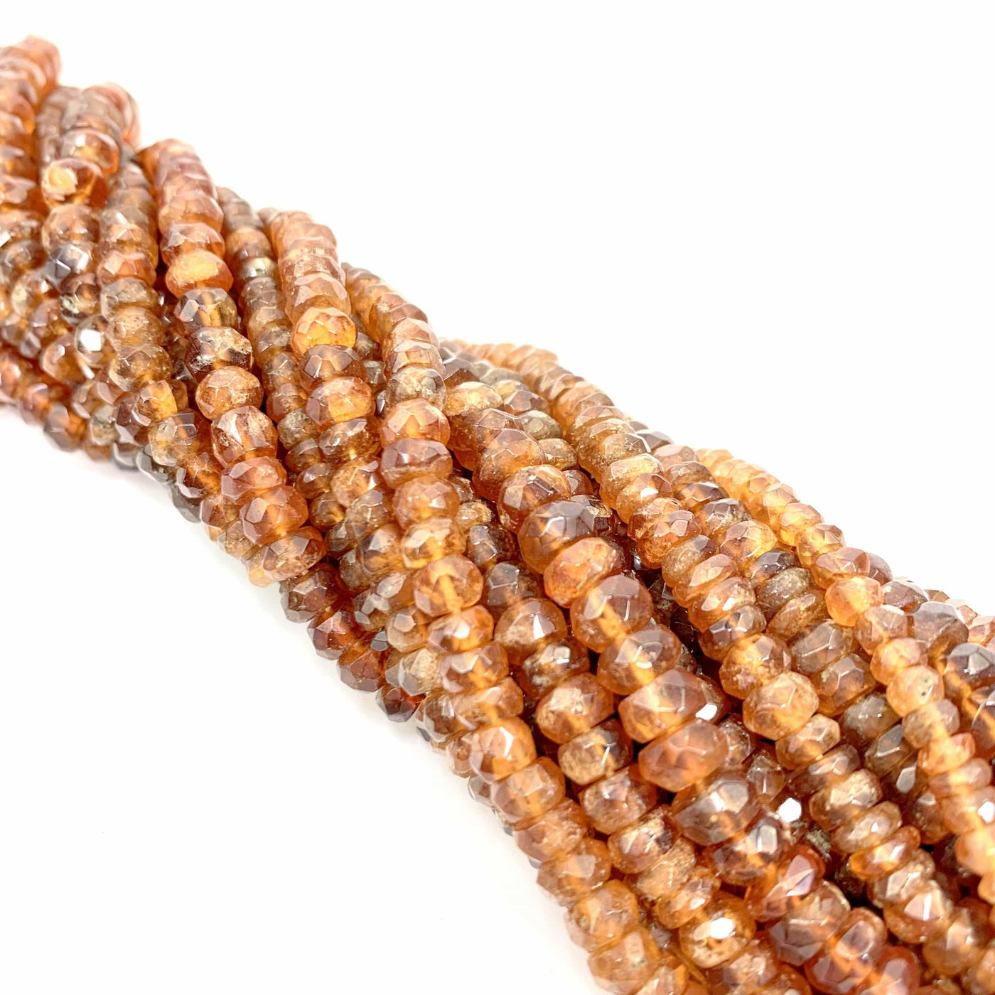 hessonite beads twisted together on a white background