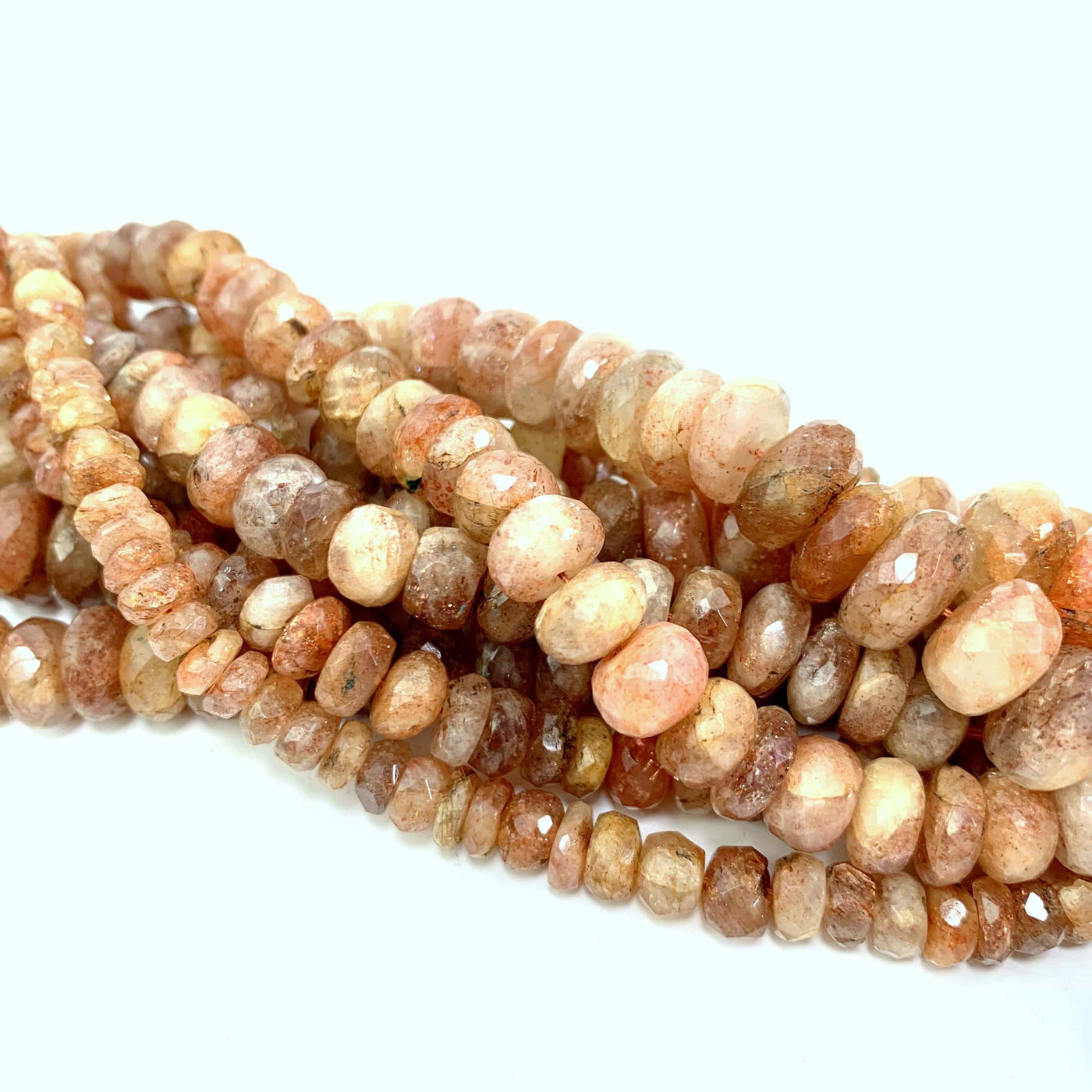 all 3 variations of sunstone faceted beads twisted together on a white background