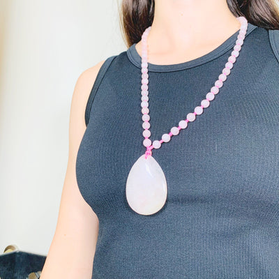 Right side angle of the Rose Quartz Tear Drop Pendant on Beaded Mala Necklace on model