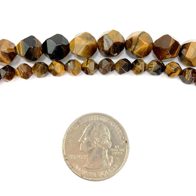 Faceted Pentadecagon Tiger Eye Beads ( bottom small, top large) on a white background next to a quarter