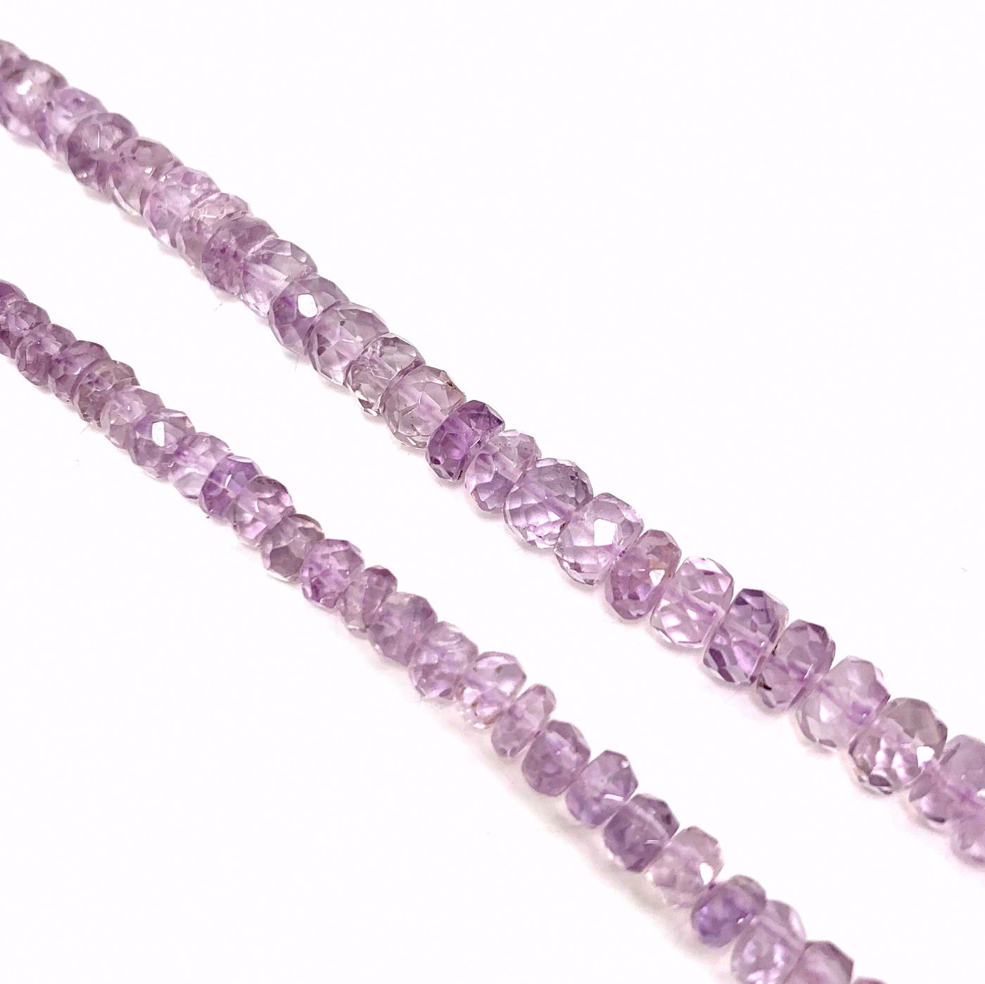 Both amethyst bead strands ( left small, right large) on a white background