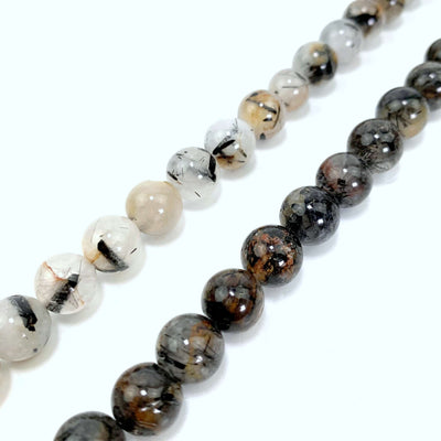 both light (left) and dark (right) rutilated quartz beads on a white background