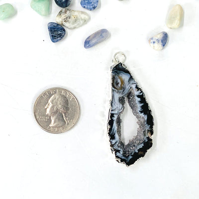 Quarter comparing size to the Agate Druzy Slice Pendant with Electroplated Silver Edge