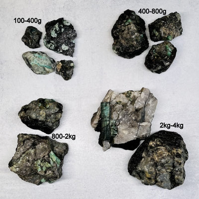 multiple raw emerald clusters displayed to show the differences in the sizes available 