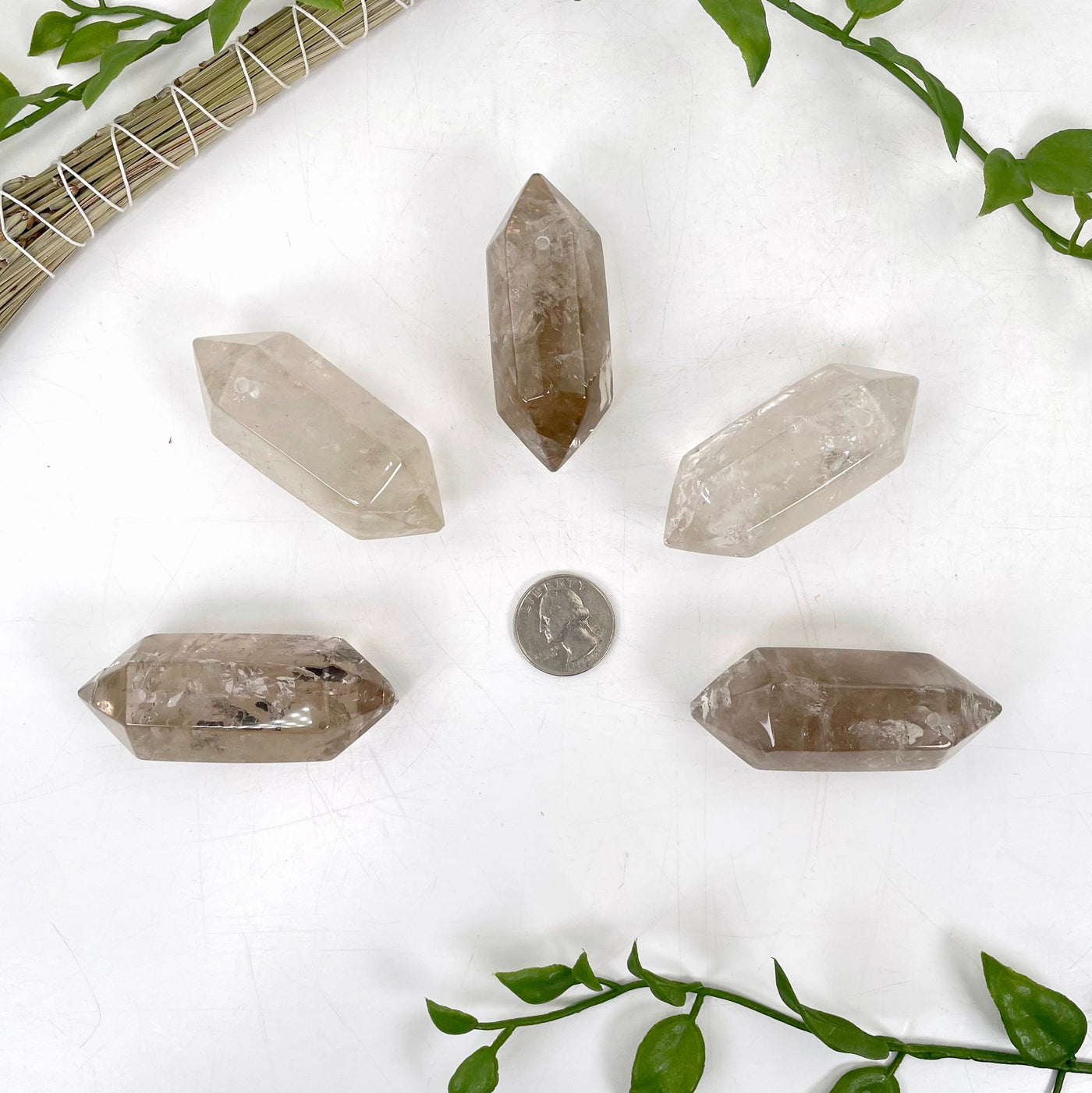 smoky quartz double terminated points laying flat around a quarter 